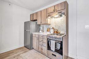 Meriden apartment for rent - a kitchen with wooden cabinets and stainless steel appliances and a refrigerator at The Meriden, Meriden, CT