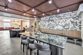 Meriden apartment for rent - a dining area with a glass table and chairs and a marble wall at The Meriden, Meriden, CT