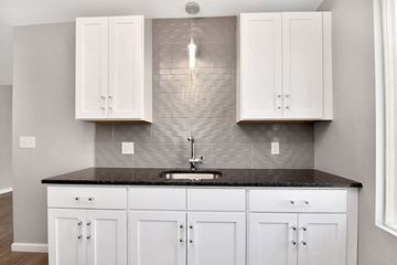 New Britain apartment for rent - a kitchen with white cabinets and a counter top and a sink