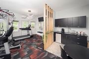 Woodbury apartment for rent - a gym with a reformer exercise machine and a kitchen with black cabinets at Woodbury Knoll, Woodbury, CT 06798