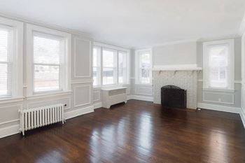 A living room with a wood floor and a fireplace
