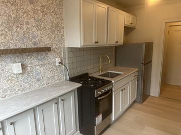 New Haven apartment for rent - A kitchen with a black stove top oven and a refrigerator.