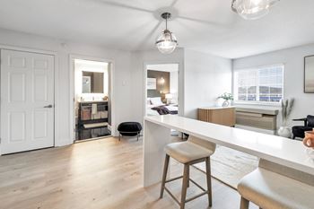 An open kitchen and living room with a white counter top