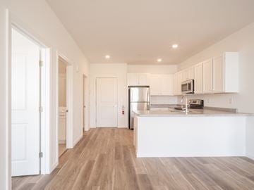 South Burlington apartment for rent - A kitchen with white cabinets and a wooden floor.