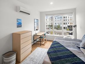 South Burlington apartment for rent - A bedroom with a bed, desk, and window overlooking a street.