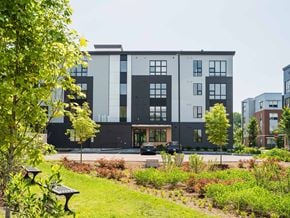 South Burlington apartment for rent - A modern building with a green lawn in front.