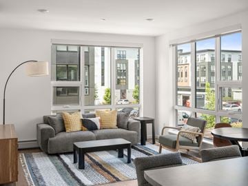 South Burlington apartment for rent - A modern living room with a grey sofa and a wooden side table.