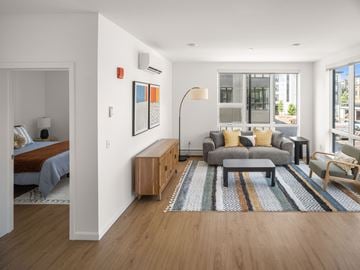 South Burlington apartment for rent - A modern living room with a grey sofa and a wooden sideboard.