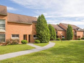 Colchester apartment for rent - A building with a red brick exterior and a green lawn in front.