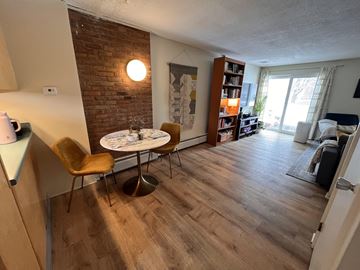 Colchester apartment for rent - A living room with a brick wall and a round table with chairs.