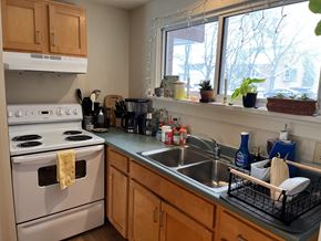 Colchester apartment for rent - A kitchen with a white stove and wooden cabinets.