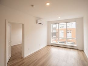 South Burlington apartment for rent - an empty living room with a large window and wooden floors