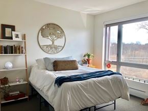 Winooski apartment for rent - A bedroom with a large bed and a window overlooking a field.