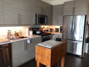 Winooski apartment for rent - A kitchen with a wooden table and stainless steel appliances.