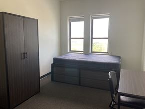 Burlington apartment for rent - a bedroom with a bed and a dresser and two windows