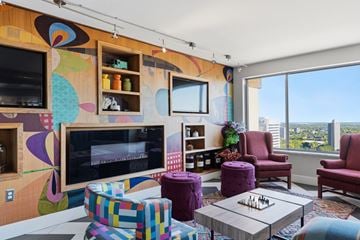 Detroit apartment for rent - A living room with a colorful mural on the wall and a chess board on the coffee table.