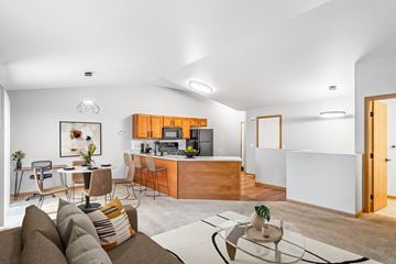 Portage apartment for rent - A modern living room with a brown sofa and a glass coffee table.