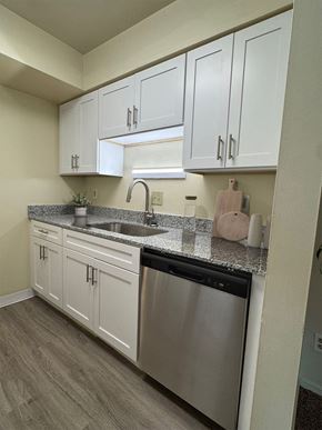 Kalamazoo apartment for rent - A kitchen with white cabinets and a stainless steel dishwasher.
