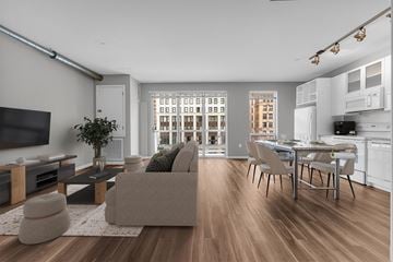 Detroit apartment for rent - A modern living room with a grey couch and a wooden floor.