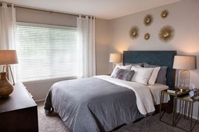 Wheeling apartment for rent - a bedroom with a bed and two mirrors on the wall