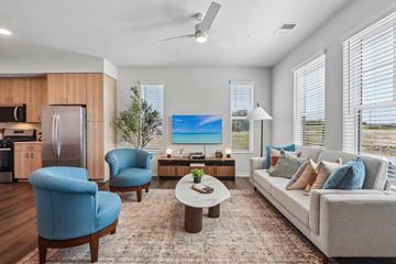 Aurora apartment for rent - A modern living room with a blue chair and a grey couch.