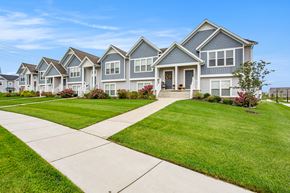 Hudsonville apartment for rent - A row of houses with a sidewalk in front.