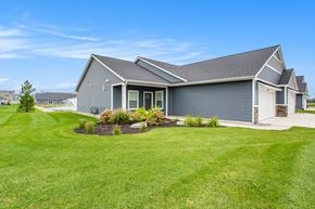Hudsonville apartment for rent - A grey house with a green lawn in front.
