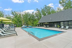 Plymouth apartment for rent - A pool with sun loungers and a building in the background.