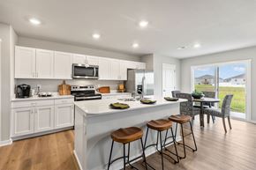 Ankeny apartment for rent - A kitchen with white cabinets and a large island with bar stools.