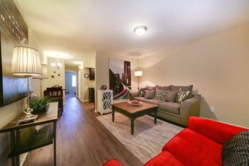 Little Rock apartment for rent - A living room with a red couch and a wooden coffee table.