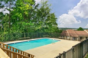 Little Rock apartment for rent - A pool surrounded by a fence and trees.