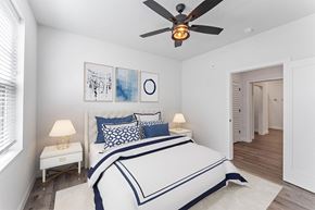 Rogers apartment for rent - A bedroom with a bed, two lamps, and a ceiling fan.