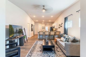 O'fallon apartment for rent - A living room with a grey couch, a black coffee table, and a painting of a landscape on the wall.