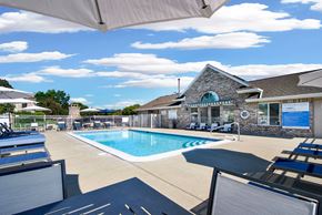 Mason apartment for rent - A pool area with sun loungers and a building in the background.