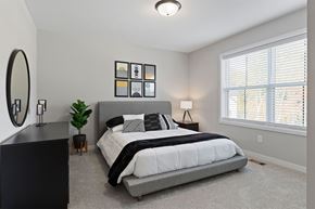 Plymouth apartment for rent - A bedroom with a large bed and a mirror on the wall.