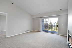 New Hudson apartment for rent - A sparsely furnished room with a sliding glass door.