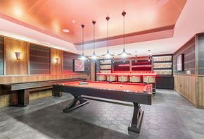 Richfield apartment for rent - A pool table is in the middle of a room with a bench and lights hanging from the ceiling.