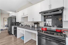Richfield apartment for rent - A modern kitchen with a black stove top oven and white cabinets.