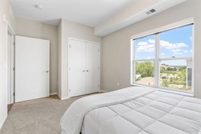 Richfield apartment for rent - A bedroom with a large bed and a view of the outdoors through a sliding glass door.