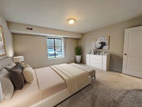 Livonia apartment for rent - A bedroom with a large bed and a window.