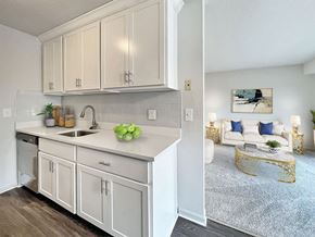 Livonia apartment for rent - A kitchen with white cabinets and a white countertop with a bowl of green apples on it.