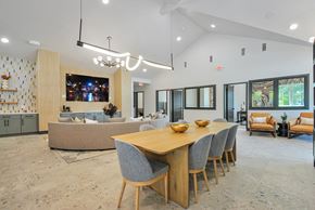 Livonia apartment for rent - A modern dining room with a long wooden table and grey chairs.