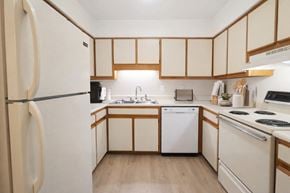 Fayetteville apartment for rent - A kitchen with wooden cabinets and a white fridge.
