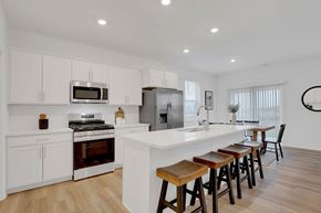 Crown Point apartment for rent - A modern kitchen with white cabinets and a wooden island.