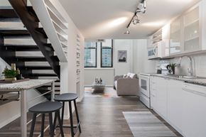 Cincinnati apartment for rent - A modern kitchen with white cabinets and a wooden floor.