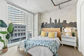 Cleveland apartment for rent - a bedroom with a bed and a city mural on the wall
