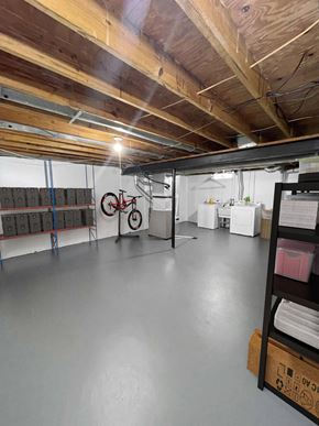 East Lansing apartment for rent - A spacious garage with a bicycle and storage shelves.