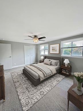 East Lansing apartment for rent - A bedroom with a bed, a ceiling fan, and a rug.
