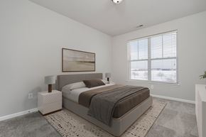 Plainfield apartment for rent - A bedroom with a large bed and a painting on the wall.