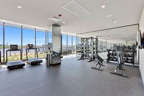 Chicago apartment for rent - a gym with floor to ceiling windows and weights and cardio equipment